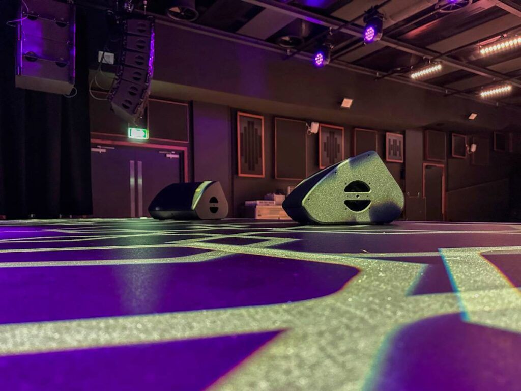 Nine L-Acoustics X12 speakers are placed across the stage for monitoring