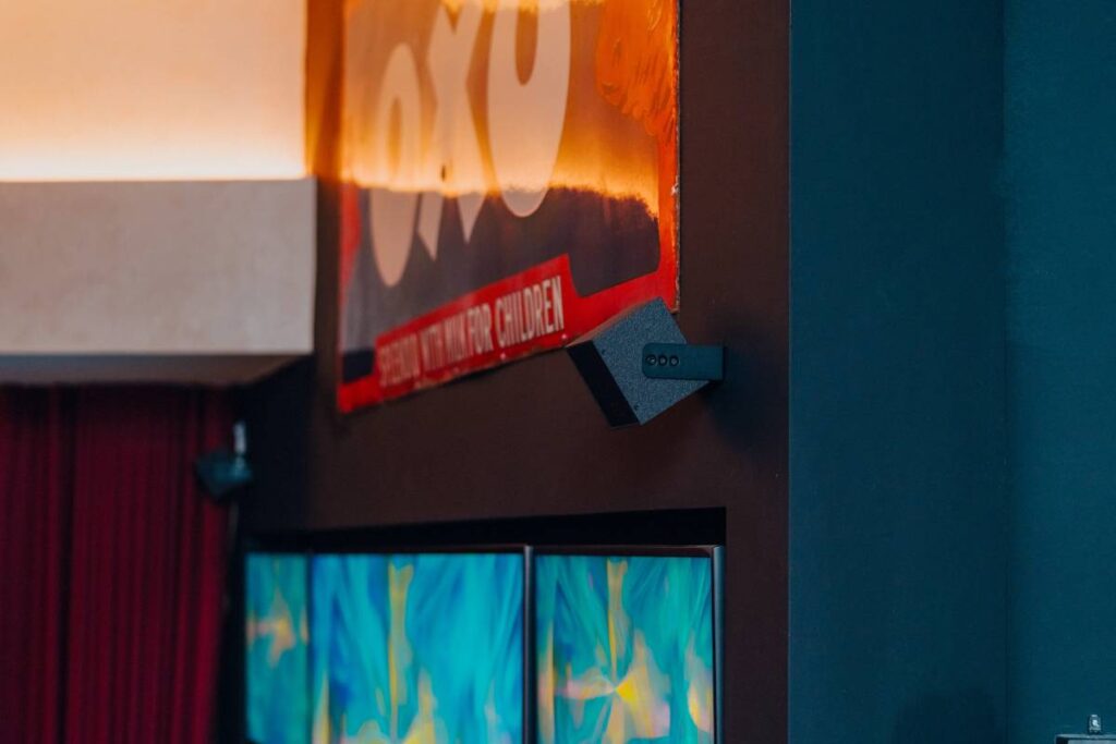 Two L-Acoustics X4i speakers sit subtly above the screen in the sports lounge.