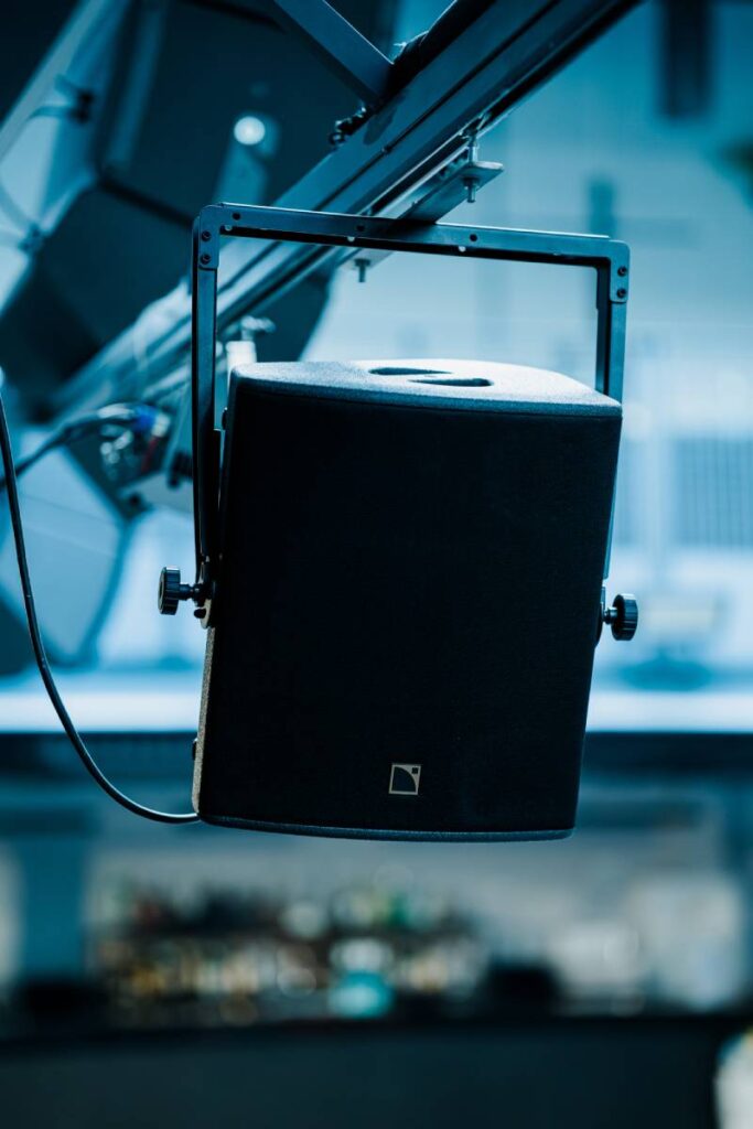 The room spans two levels - balcony coverage uses two X12, supplemented by further X12 and X8 in distributed positions across left, right and centre to maintain tonal consistency throughout the upper tier