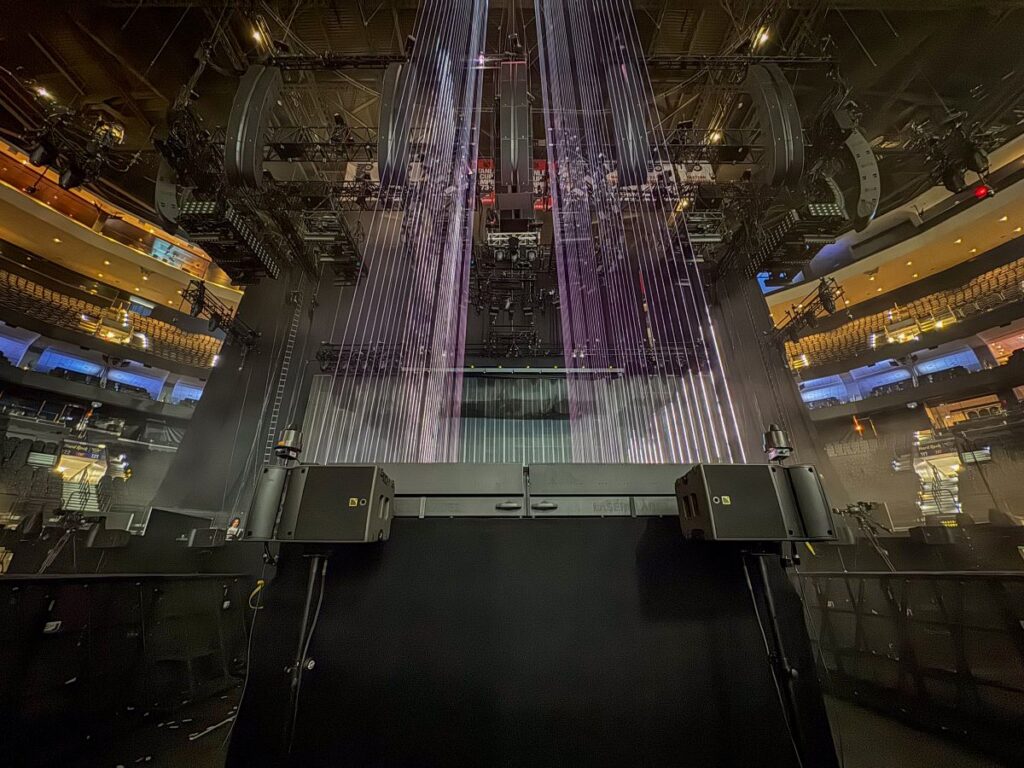 Fourteen L-Acoustics A10 Wide spread out across the front of the stage lip and thrust supplied spatial front-fill
