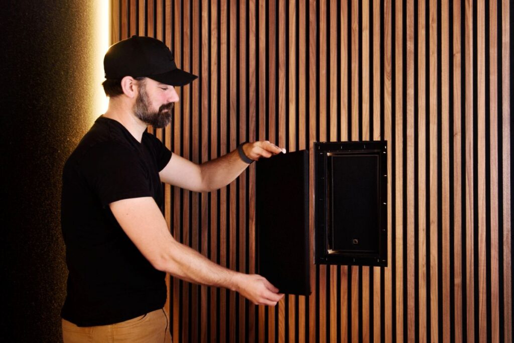 Blue Rocket Solutions Owner Ryan Guest installing a custom, acoustically-transparent cover over one of the L-Acoustics X6i surrounds