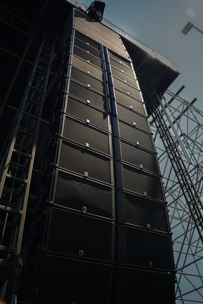 The main hangs extend L-Acoustics K1 with K1-SB, focusing sound on the audience and keeping spill away from the buildings behind the stage